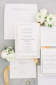 the wedding stationery is laid out on top of each other with flowers and ribbons