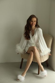 a woman is sitting on a chair with her legs crossed and she has long hair