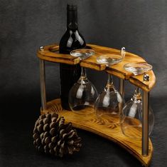 there are wine glasses and bottles on the wooden shelf with pine cones next to it