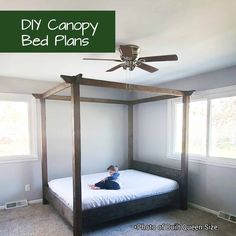 a child laying on a bed in a bedroom with a ceiling fan and window behind it