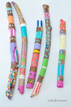 four different colored pencils sitting next to each other on top of a white surface