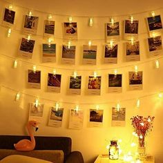 a living room with lights strung from the ceiling and pictures on the wall above it