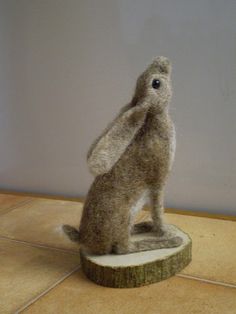 a stuffed animal sitting on top of a wooden base