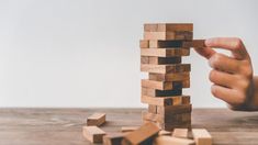 someone is playing with wooden blocks on the table