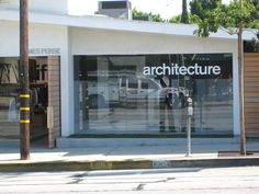 a store front with the words architecture on it's glass door and parking meter