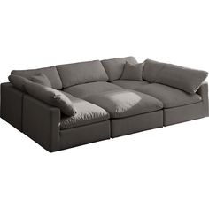 a large sectional couch with pillows on it's back and side ends, facing away from the camera