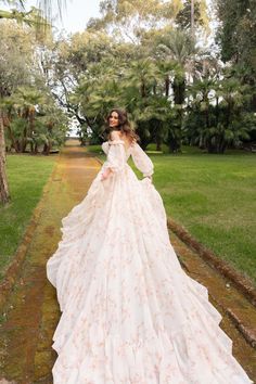 a woman in a wedding dress standing on a path