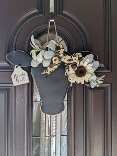 the front door is decorated with an antler head and sunflowers on it