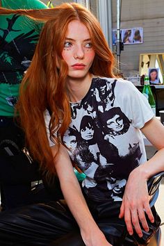 a woman with red hair sitting in a chair