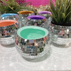 several disco ball vases sitting on a table with succulents in them