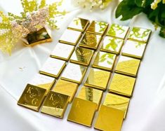 gold foiled business cards on a table with flowers and vases in the background