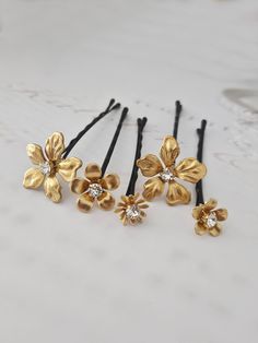 Elegant gold flowers with sparkling crystals ... place them in your hair to create a unique design with these delicate hair flowers!  You will receive FIVE crystal flower hair pins - TWO large and THREE smaller flowers...securely wired onto high quality black bobby pins for easy placement in any hair style.   Each flower is lightweight and range in size from .3/8" to 7/8" diameter.   A great gift for your bridesmaids and flower girls, too! Carefully packaged and shipped via USPS Mail with tracking. Selling on Etsy since 2008! Designs and photos copyright © One World Designs  Thank you for visiting my shop, Bonnie =) OWDJewelry.etsy.com Gold Hair Pins, Hair Piece Wedding Hair, Hair Piece Wedding, Flower Hair Pins, Gold Hair Pin, Bridal Hair Piece, Flower Comb, Hair Gift, Hair Flowers