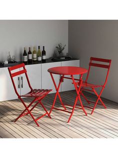 two red chairs sitting next to each other on top of a wooden floor