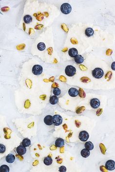 blueberries and pistachios are on top of rice krispy treat bars