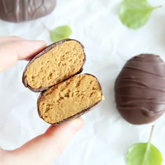 two pieces of peanut butter in the palm of someone's hand next to a chocolate egg