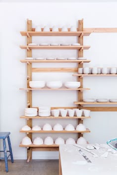 the shelves are filled with bowls and plates