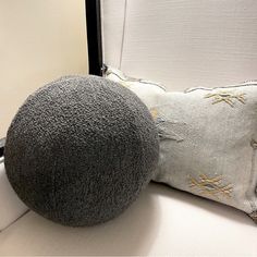 a gray pillow sitting on top of a white couch