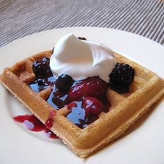 a waffle topped with fruit and whipped cream