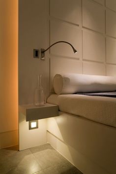 a bedroom with a bed, night light and nightstand