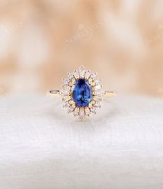 a blue and white diamond ring sitting on top of a table