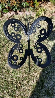 a metal butterfly sculpture sitting in the grass