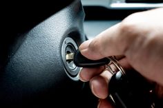 a person is holding the keys to a car's steering wheel and turning it on