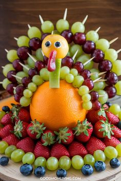 Colorful fruit turkey centerpiece made with grapes, strawberries, blueberries, and an orange, perfect for Thanksgiving celebrations. Fruit Kabob Ideas, November Party Themes, Thanksgiving Food Table Display, Individual Fruit Cups, Kabob Ideas, Food Table Display, Thanksgiving Theme Party, Easy Thanksgiving Dish, Turkey Kabobs