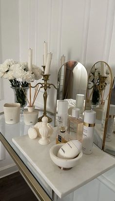 a table topped with vases filled with flowers and personal care items on top of it