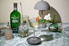 a table topped with glasses and bottles of alcohol on top of a marble countertop