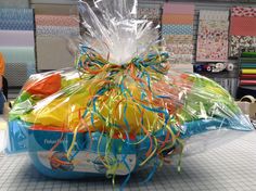 a plastic bag filled with lots of colorful streamers on top of a tiled floor