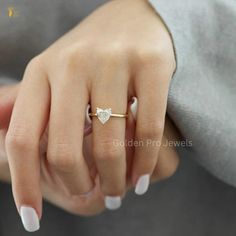 a woman's hand with a diamond ring on her left hand and white nails