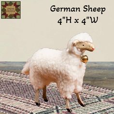 a white sheep standing on top of a rug