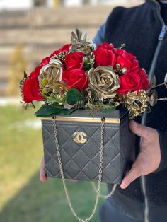 a person holding a chanel bag with roses in it and chain around the handle