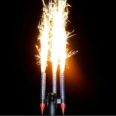 two rockets are lit up in the dark with bright yellow and red lights on them