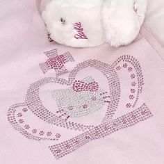 a white teddy bear laying on top of a pink blanket