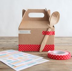 a cardboard box with a fork, spoon and tape