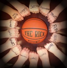 a group of hands holding a basketball with the words on it