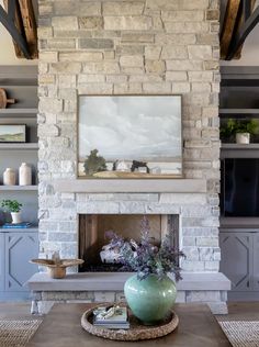 a living room filled with furniture and a fire place in front of a stone fireplace