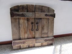 two wooden doors sitting on top of a carpeted floor next to a white wall