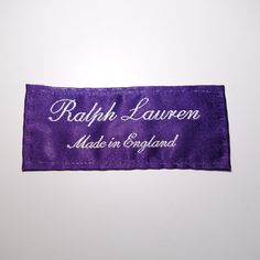 a purple name tag with white writing on the front and back of it that says, ralph lauren made in england