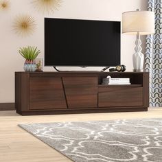 a flat screen tv sitting on top of a wooden entertainment center in a living room