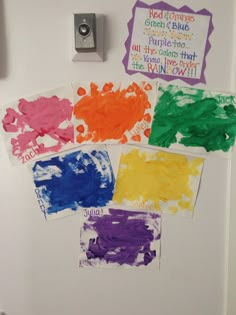 the refrigerator door is covered in different colored paper and magnets that read red, orange, purple, green, blue