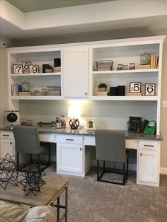 a home office with white cabinets and gray chairs