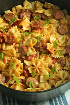 a skillet filled with pasta and sausage