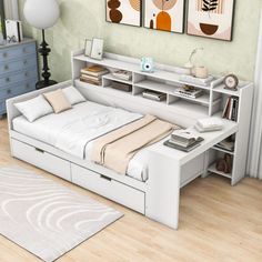 a white bed sitting on top of a wooden floor next to a dresser and book shelf