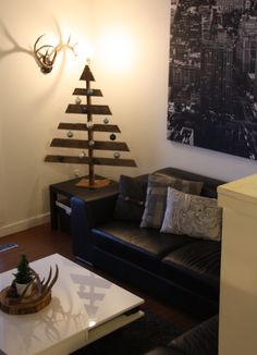 a living room filled with furniture and a christmas tree on top of a coffee table