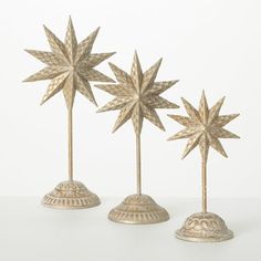 three gold star shaped candlesticks sitting on top of each other