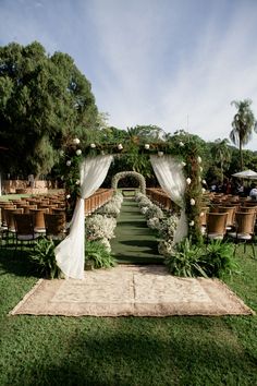 an outdoor wedding setup with white drapes and greenery