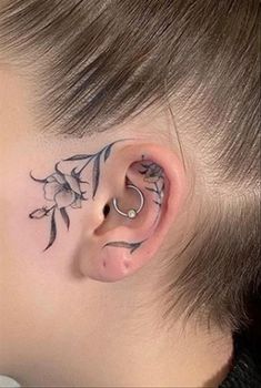 a woman with tattoos on her face and behind the ear