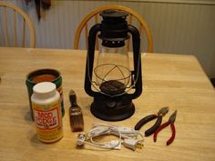 some tools are sitting on top of a wooden table next to a lantern and other items